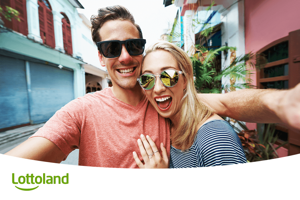 Fröhliches Paar macht Selfie auf Reisen, voller Freude – bei Lottoland die Gewinnchancen beim Lotto systematisch verbessern