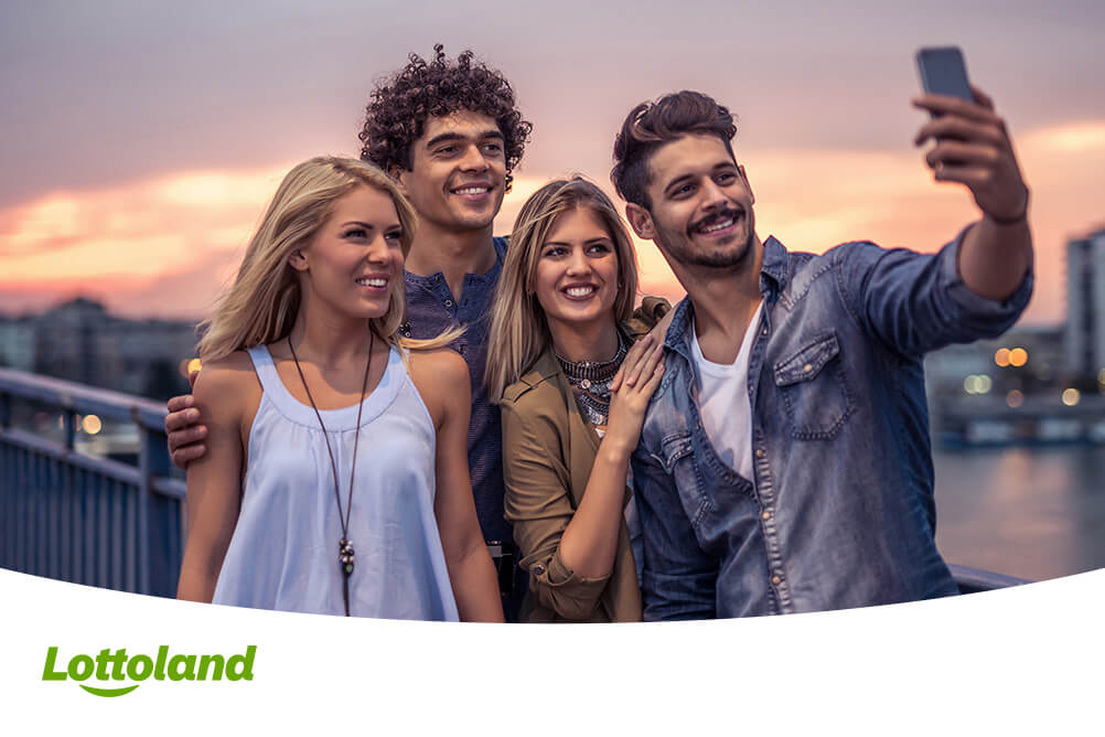 Vier Freunde machen ein Selfie nachdem sie ihren Lottogewinn abgeholt haben